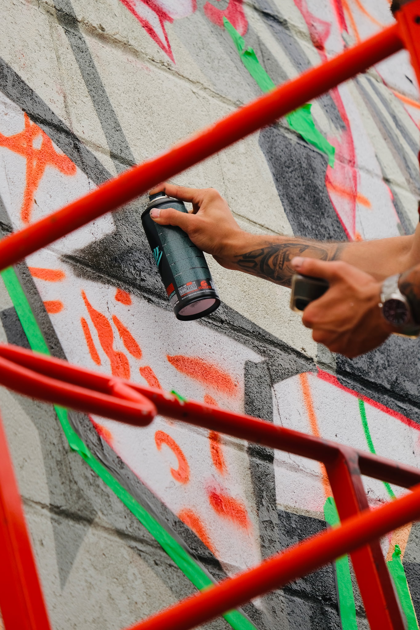 Artist painting a mural from a lift